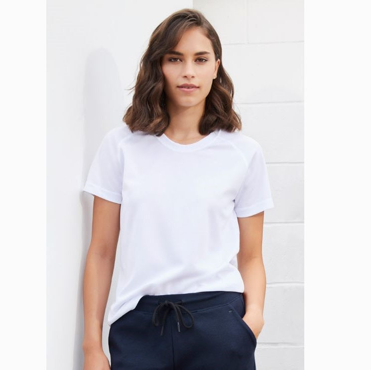 A woman wearing a white Biz Collection crew neck t-shirt with short sleeves, paired with dark pants.