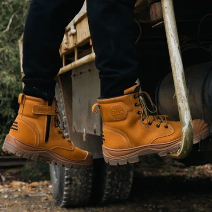Worker with safety boots on climbing into truck
