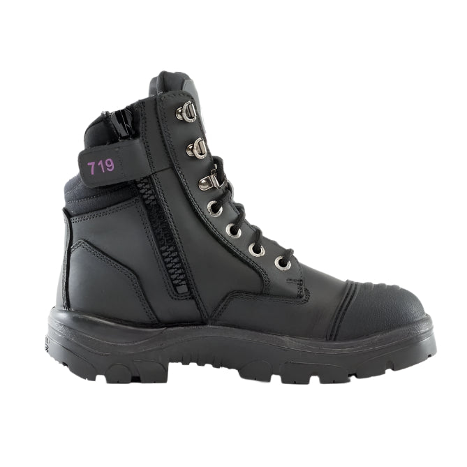 A black Steel Blue ladies safety boot with a scalloped collar, padded tongue, and side zipper. It features a lace-up front and a steel toe cap.