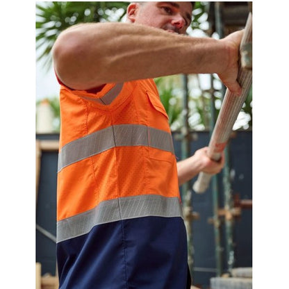 Person wearing an orange high-visibility vest holding a tool outdoors.