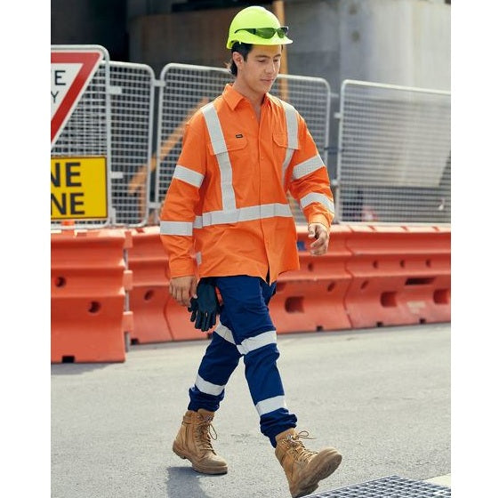 Person wearing high-visibility safety clothing and a hard hat on a construction site.