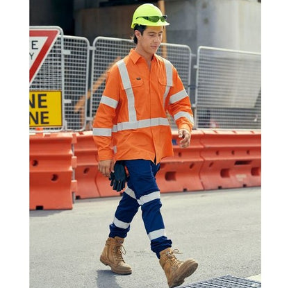 Person wearing high-visibility safety clothing and a hard hat on a construction site.