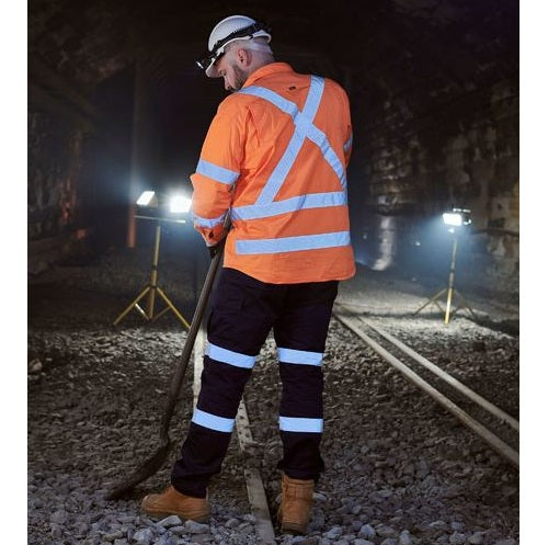 Person in high-visibility safety gear working on a railway track at night.