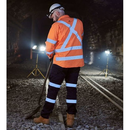 Person in high-visibility safety gear working on a railway track at night.