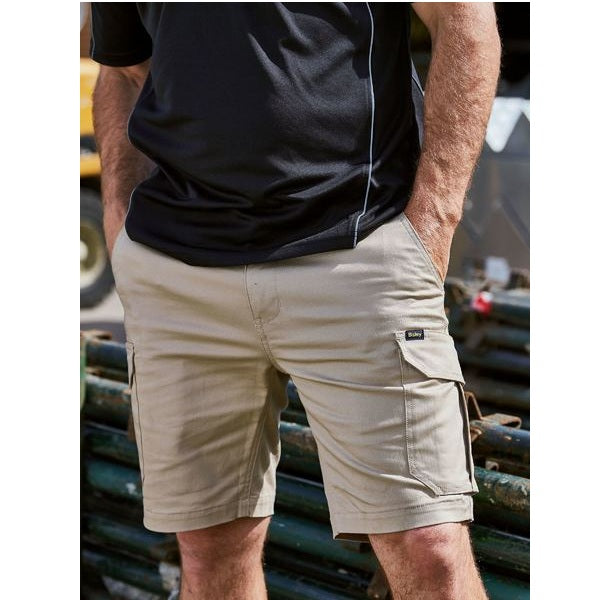 Person wearing beige cargo shorts and a black shirt with a blurred background