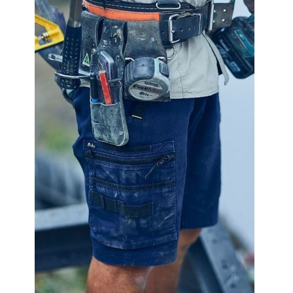 Person wearing a tool belt with various tools and equipment.