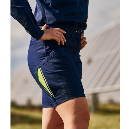 Person wearing navy shorts with a green stripe outdoors