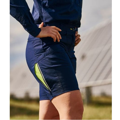 Person wearing navy shorts with a green stripe outdoors