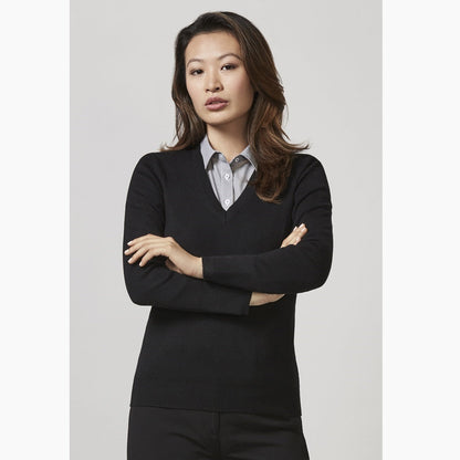 A woman wearing a black V-neck knit pullover with long sleeves, paired with a collared shirt underneath.