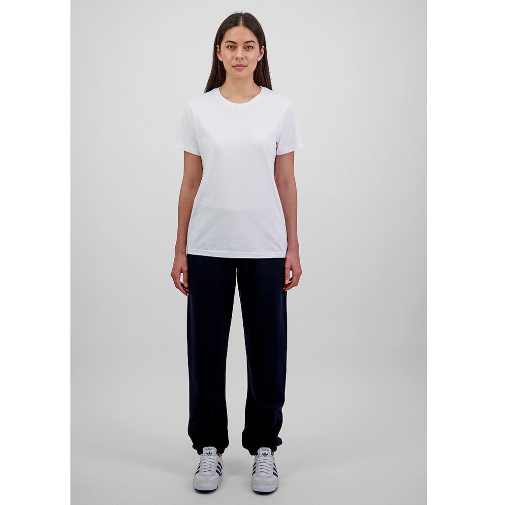 Person wearing a white t-shirt and navy pants on a gray background