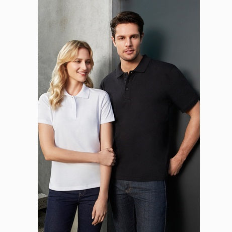 A man and a woman standing next to each other, wearing a white Biz Collection P112LS Ice Ladies Polo and a black polo shirt, respectively.