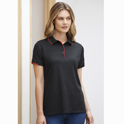 A woman wearing a black short-sleeved polo shirt with red collar and sleeve cuff highlights, and a button-through piping placket.