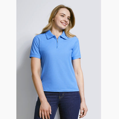 A woman wearing a blue Biz Collection ladies' micro waffle polo with a collar, short sleeves, and a zipper placket.