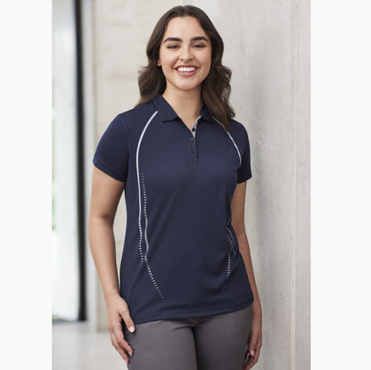 A woman wearing a navy blue Biz Collection ladies' polo shirt with a self-fabric collar and contrast print design on the front and back.