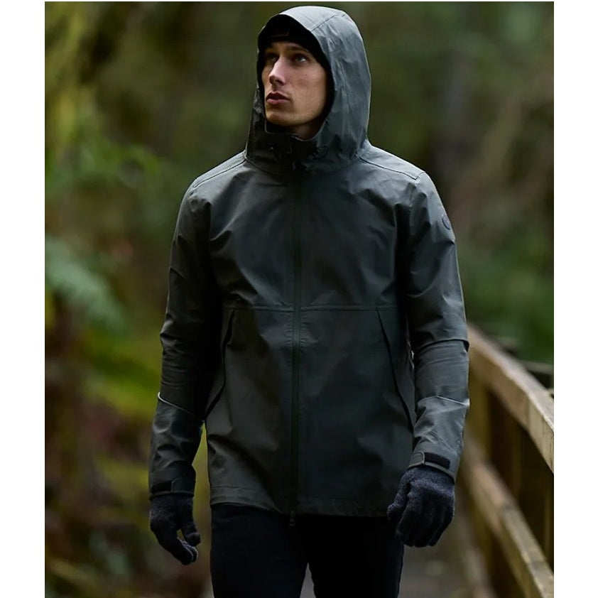 Person wearing a dark raincoat in a forest setting