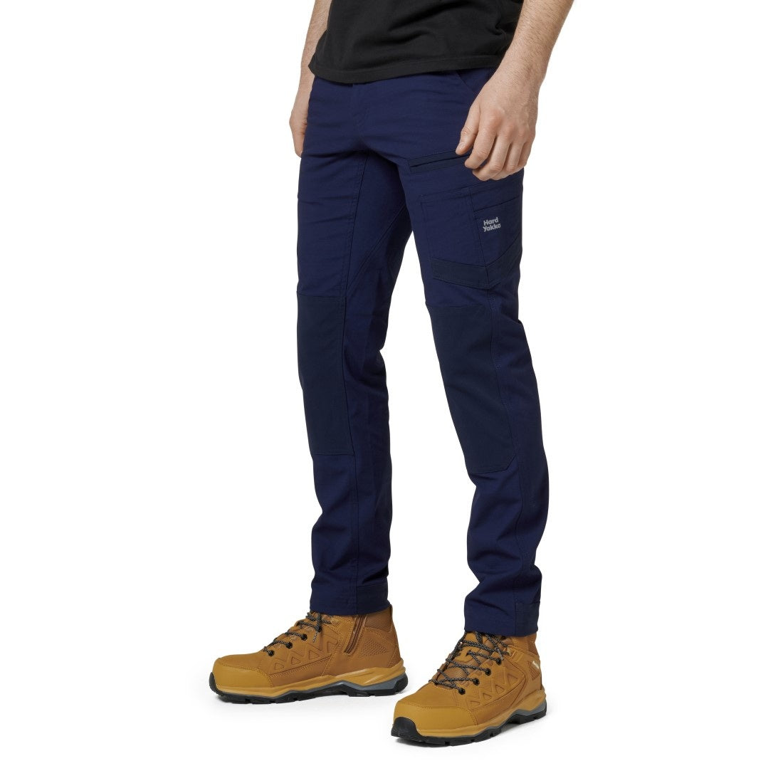 Person wearing navy pants and brown boots on a white background