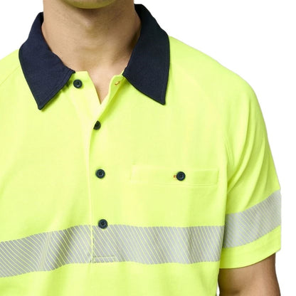 Close-up of a person wearing a bright yellow safety shirt with reflective stripes on a white background