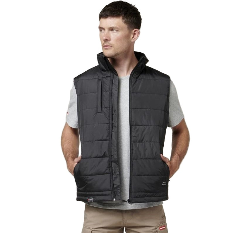 Man wearing a black quilted vest on a white background