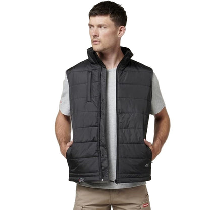 Man wearing a black quilted vest on a white background