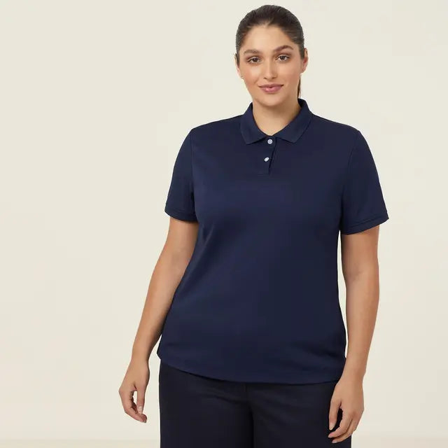 Professional woman wearing an NNT CATU58 navy blue polo shirt against a beige background