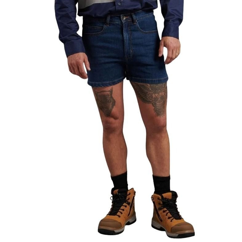 Person wearing blue denim shorts and brown work boots on a white background