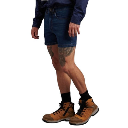 Person wearing blue denim shorts and brown work boots on a white background