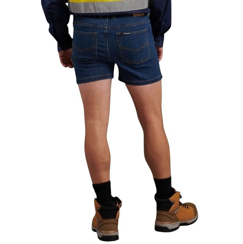 Person wearing blue denim shorts, brown work boots, and a high-visibility jacket on a white background