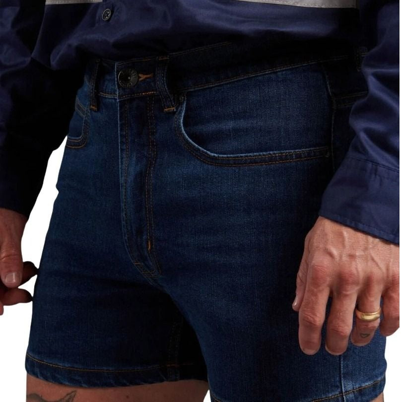 Person wearing dark blue denim shorts with a plain background