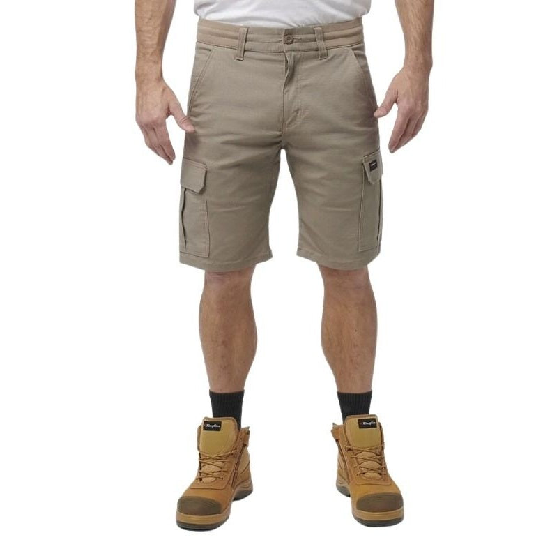 Person wearing beige cargo shorts and brown boots on a white background