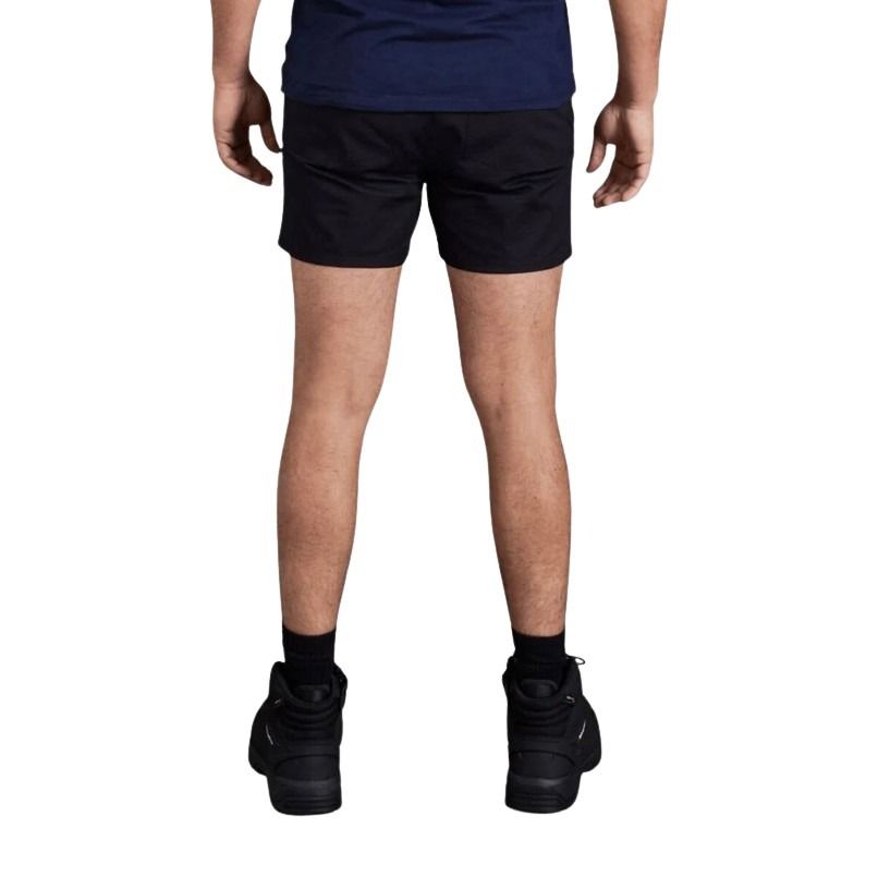 Person wearing black shorts and black shoes on a white background