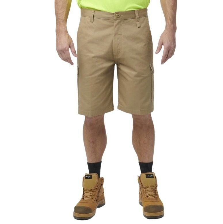 Person wearing beige cargo shorts and brown work boots on a white background