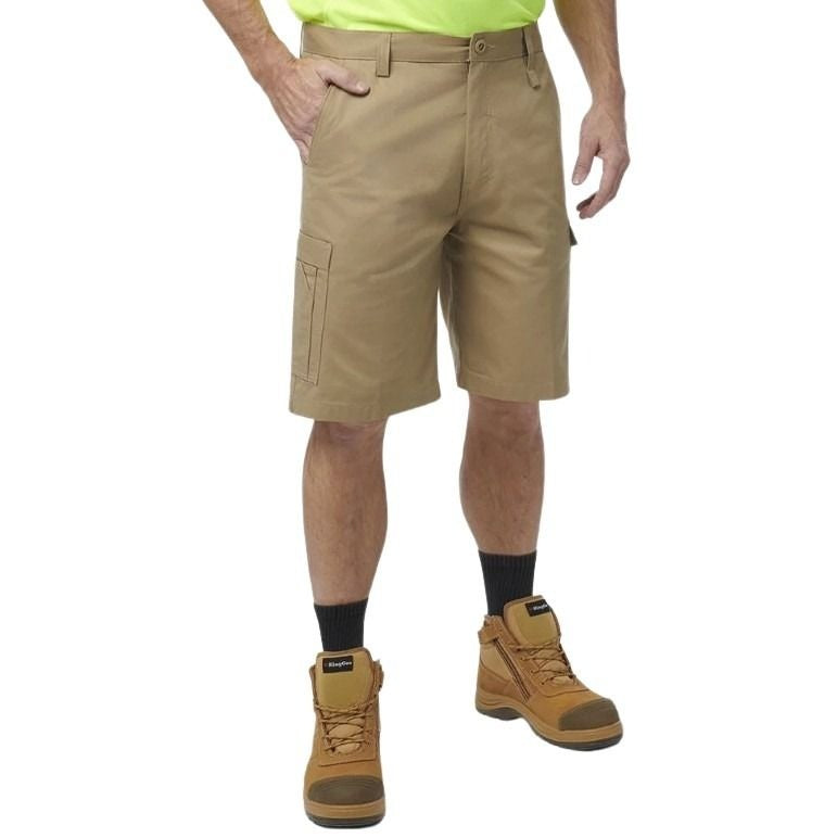 Person wearing tan work shorts, black socks, and brown boots on a white background
