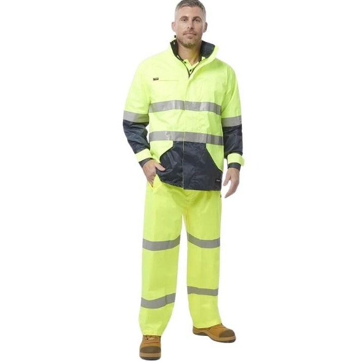 Person wearing a high-visibility yellow and black work suit on a white background