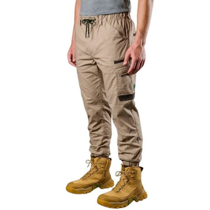 Person wearing beige cargo pants and yellow boots on a white background