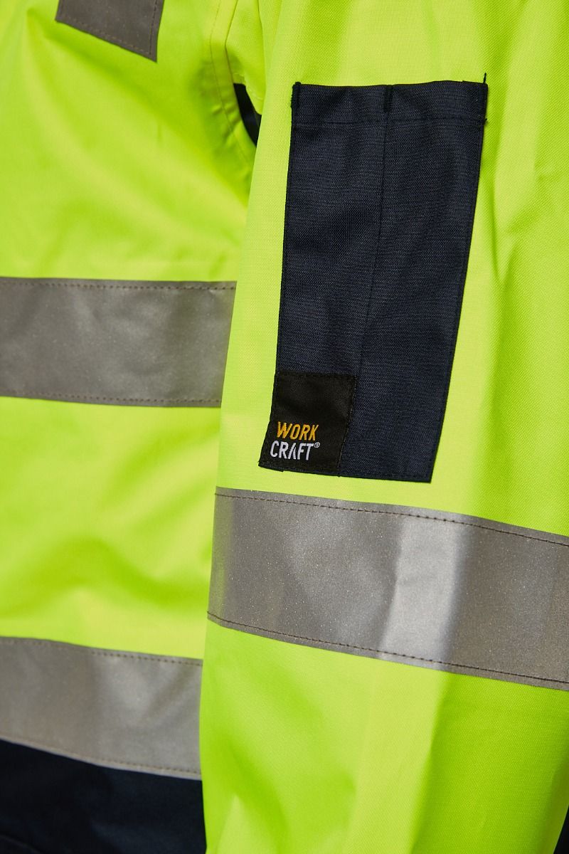 Close-up of a high-visibility jacket with reflective stripes and 'Work Craft' branding.