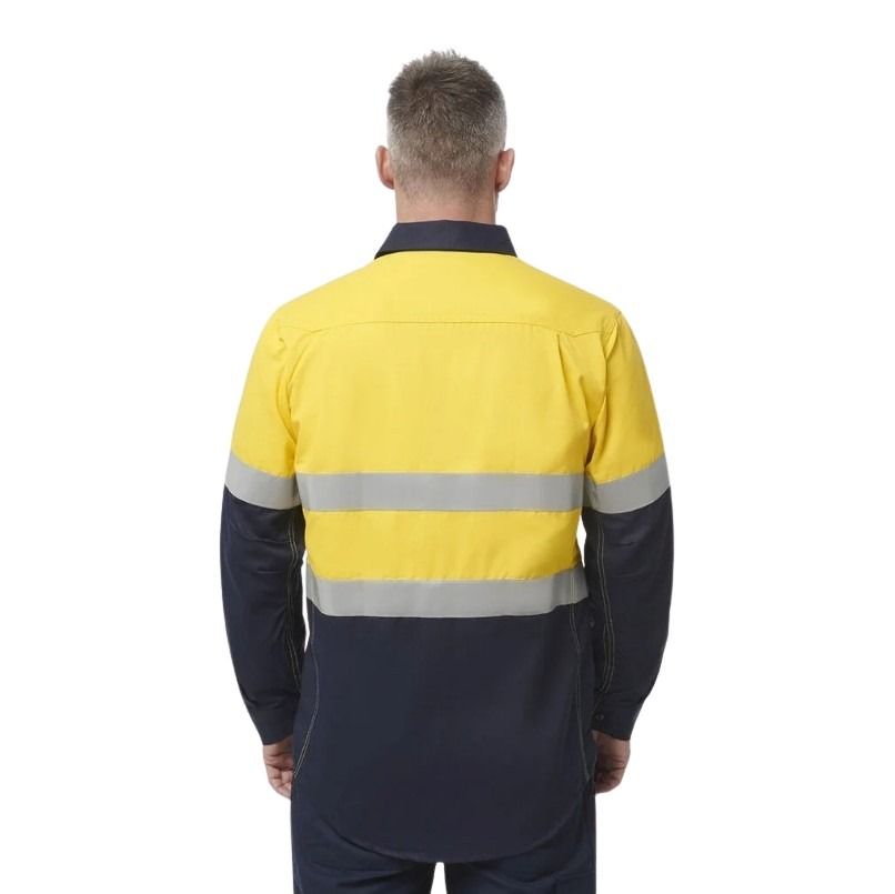 Person wearing a yellow and navy work jacket with reflective stripes on a white background