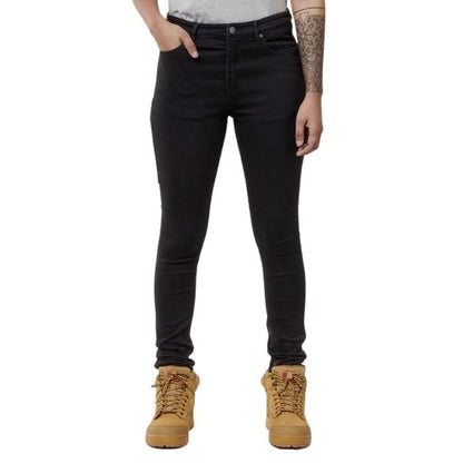 Person wearing black jeans and tan boots on a white background