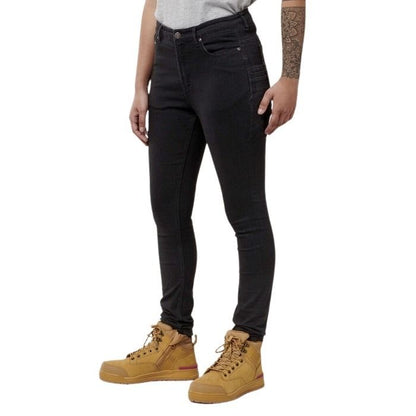 Person wearing black jeans and tan boots on a white background
