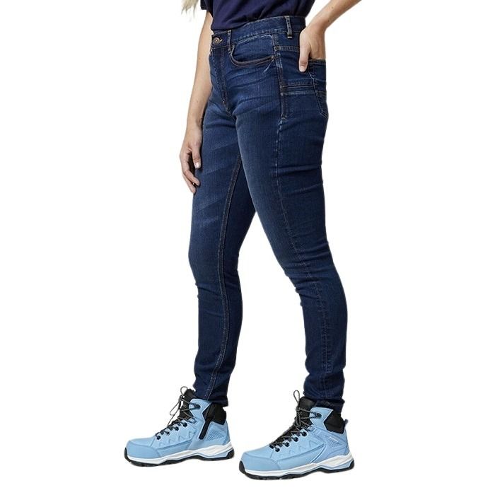 Person wearing blue jeans and light blue hiking boots on a white background