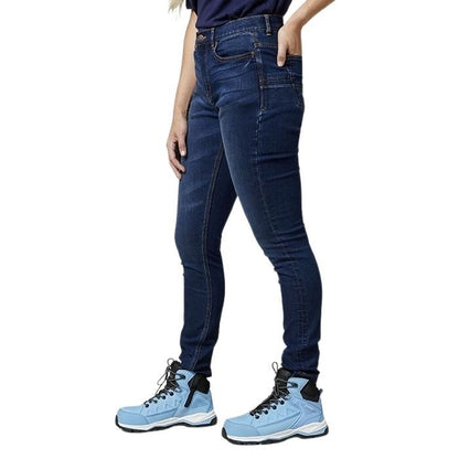 Person wearing blue jeans and light blue hiking boots on a white background